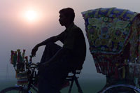 Rickshaw driver relaxes during sunset outside Dhaka, Bangladesh (photo: Michael Lund)